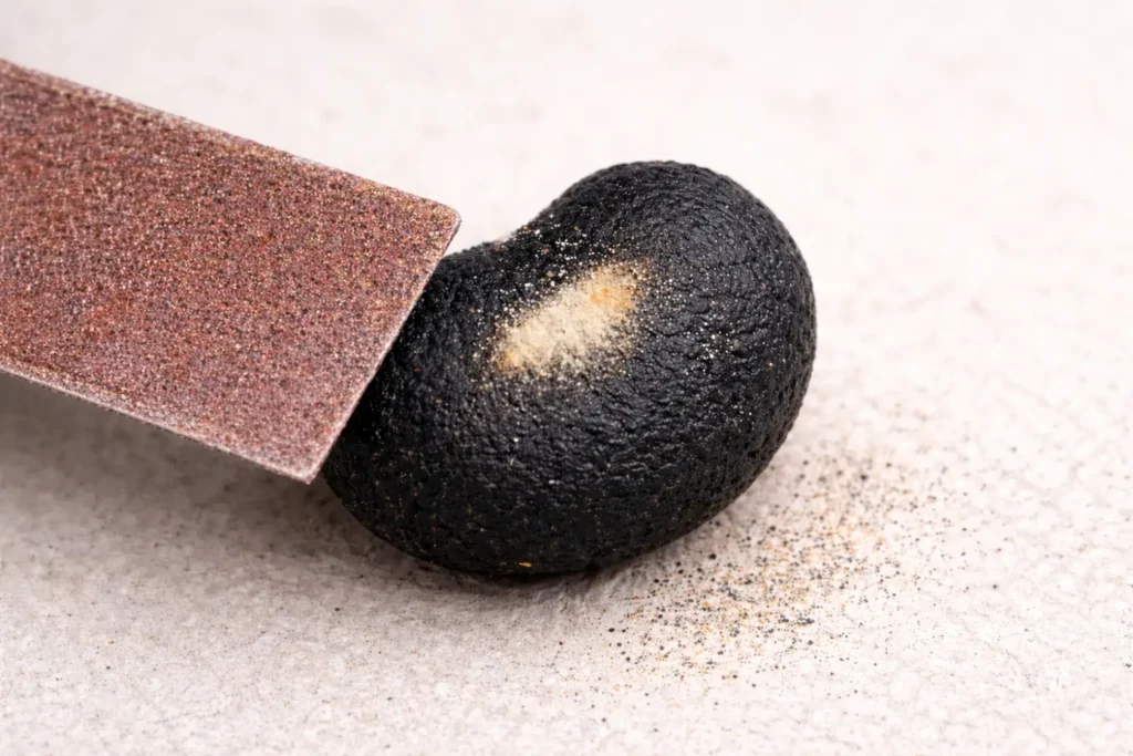 Schuur één zijde van het zaad oppervlakkig, totdat de kleur iets lichter wordt. Beschadig nooit het witte binnenste. Week het zaad daarna meteen in water.